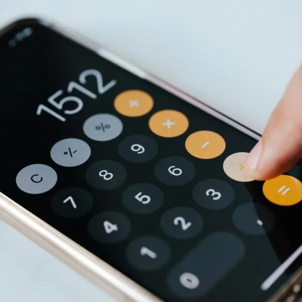 Calculator with a finger pressing the + key