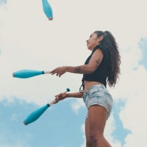 A young adult female throwing skittles into the air