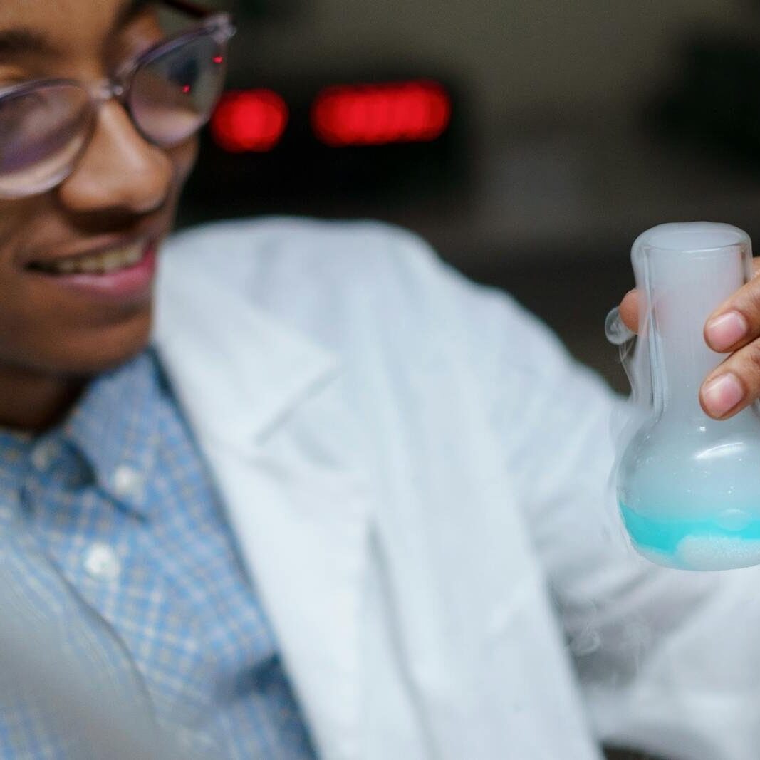 Close-up of a young scientist examining a chemical reaction in a laboratory.