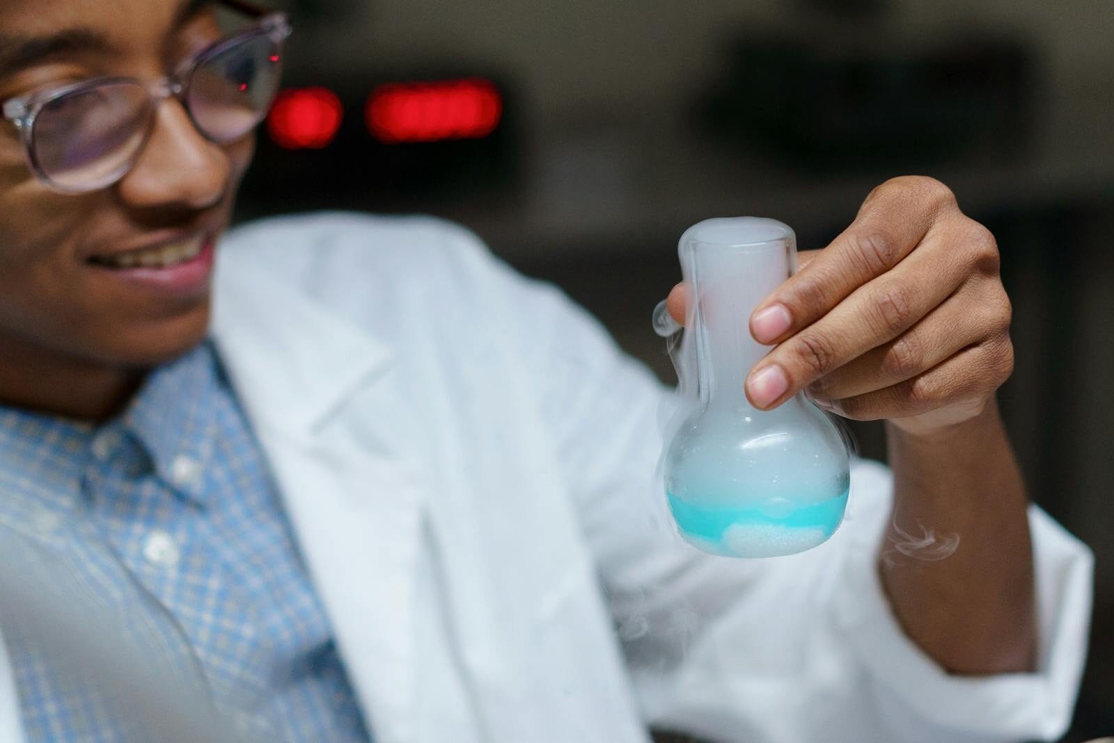 Close-up of a young scientist examining a chemical reaction in a laboratory.