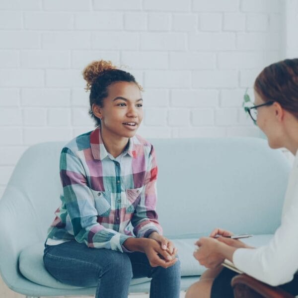 Teenager and therapist in a calm counseling environment.