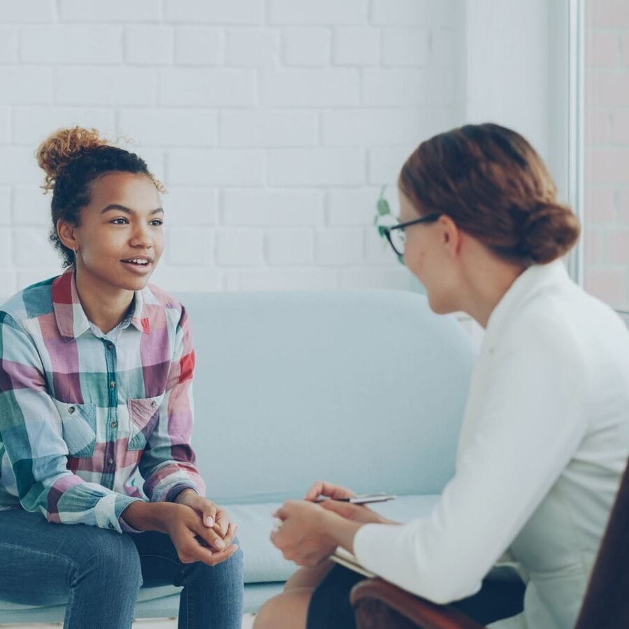 Teenager and therapist in a calm counseling environment.