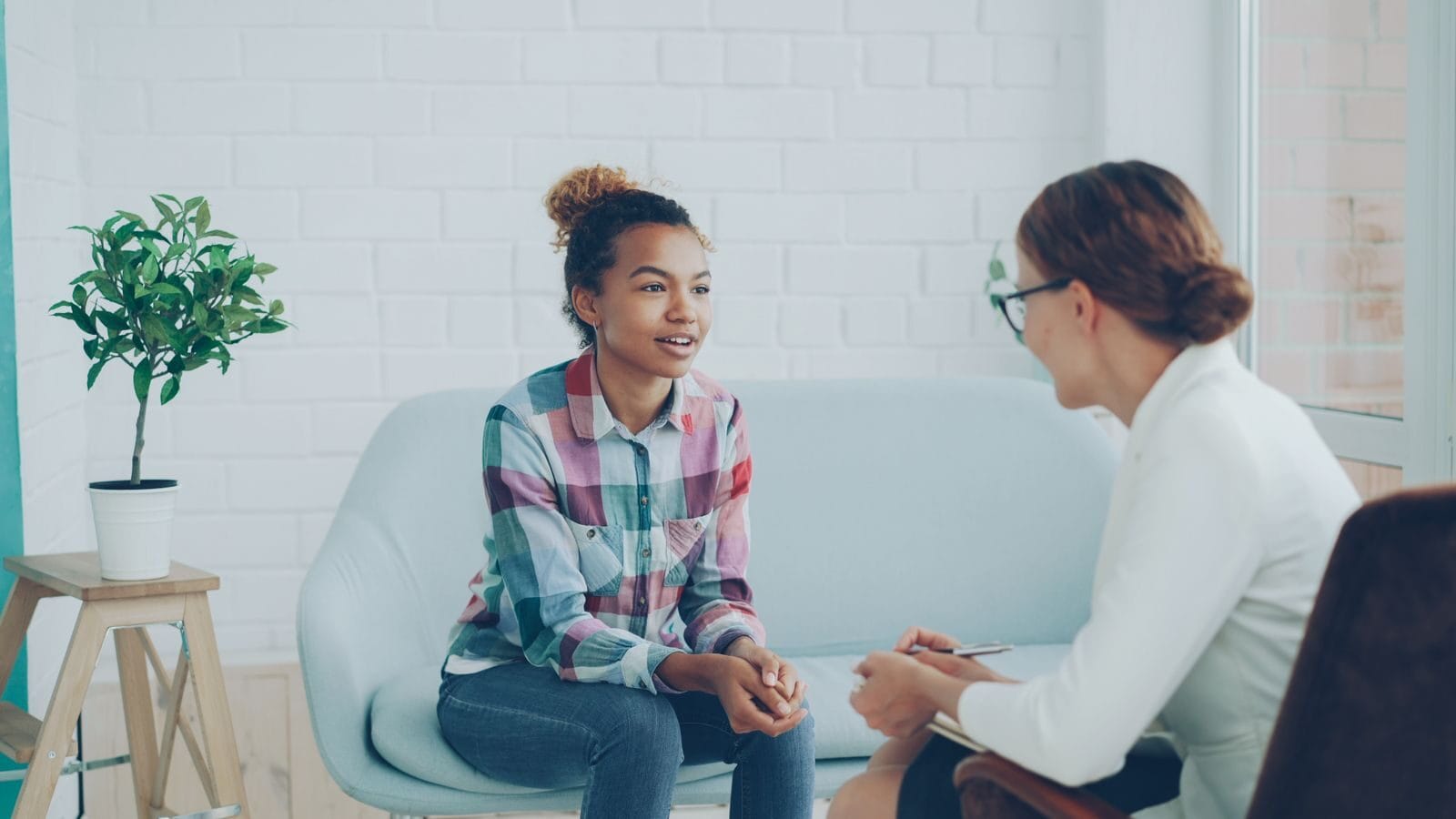 Teenager and therapist in a calm counseling environment.